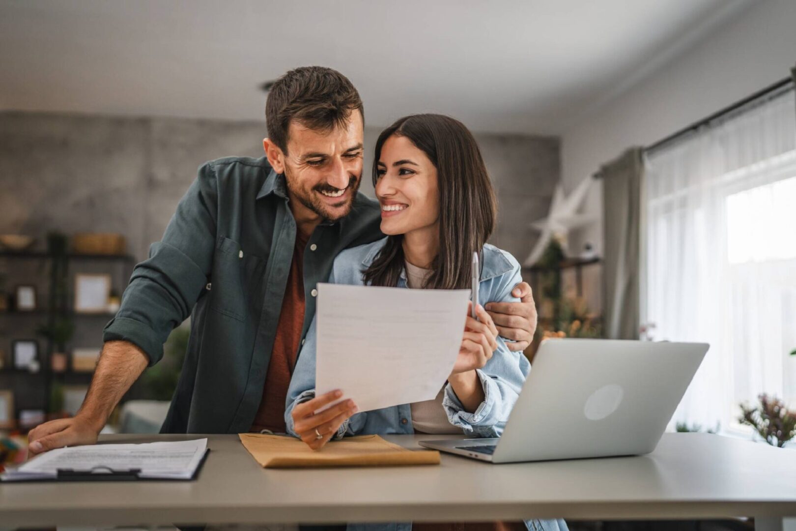 A happy couple reviewing documents together at home.
