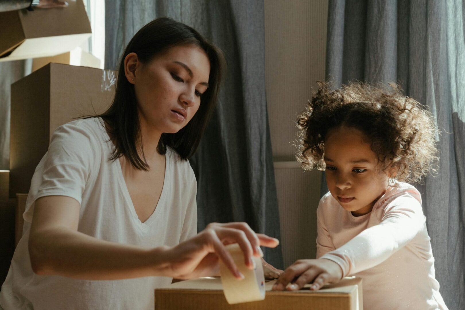 A woman and child engage in a hands-on activity at a table.