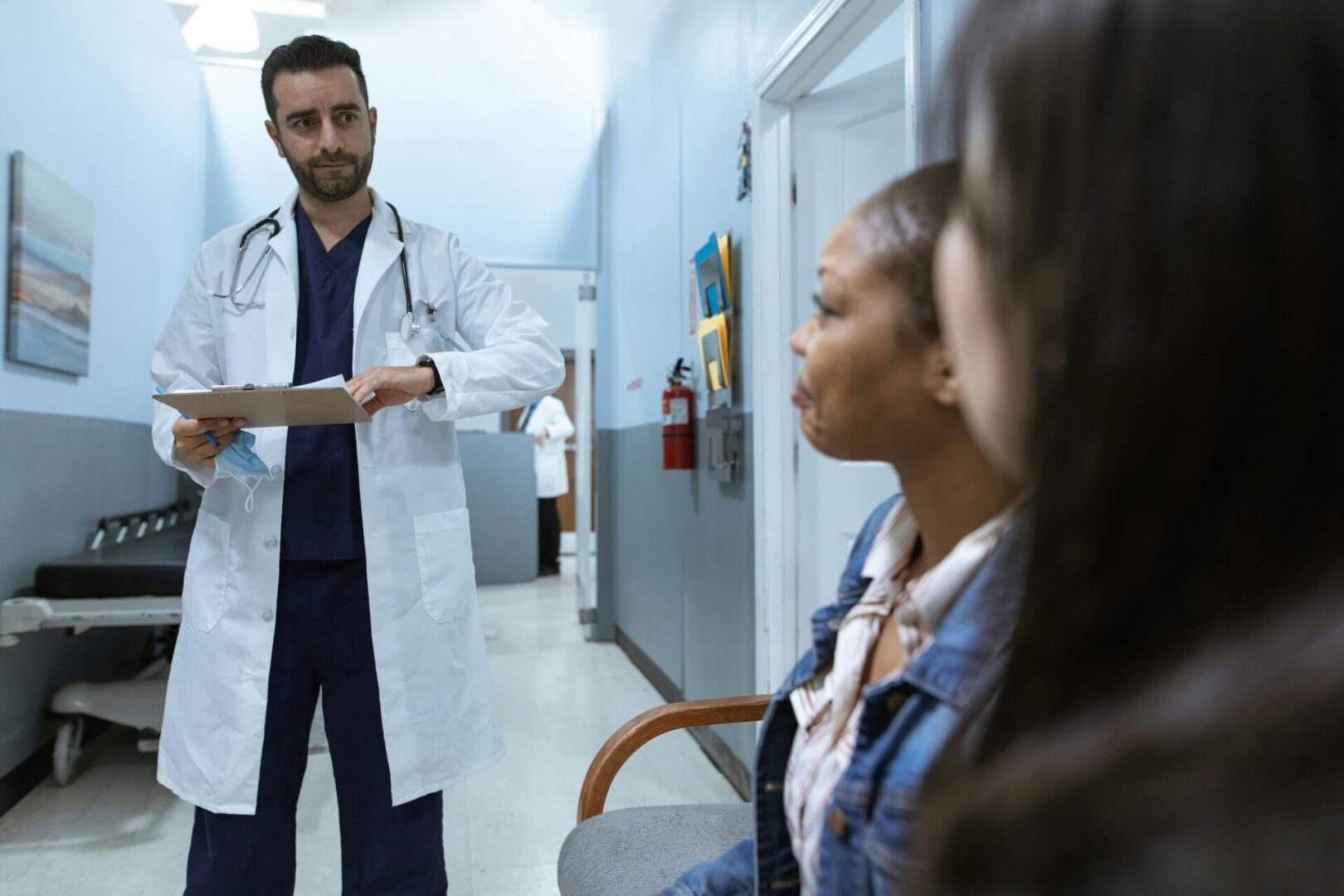 Doctor explaining medical information to patients in a hospital corridor.