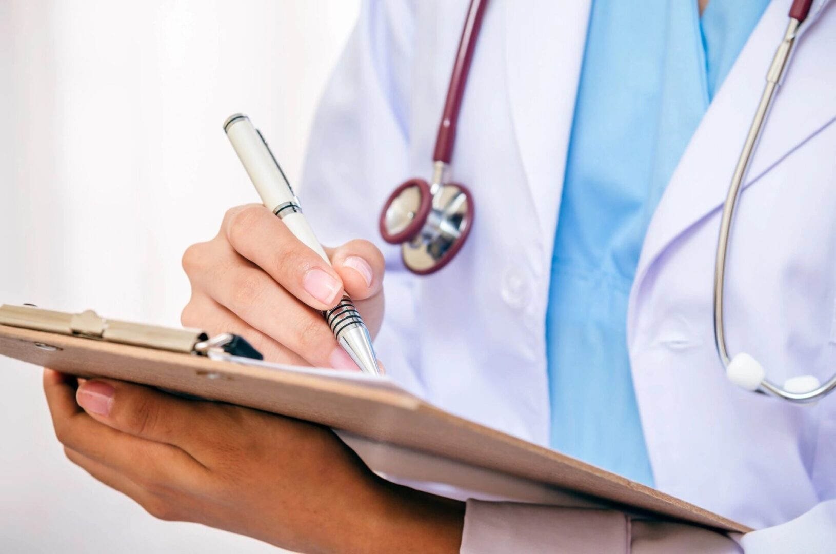 Doctor writing notes on a clipboard.