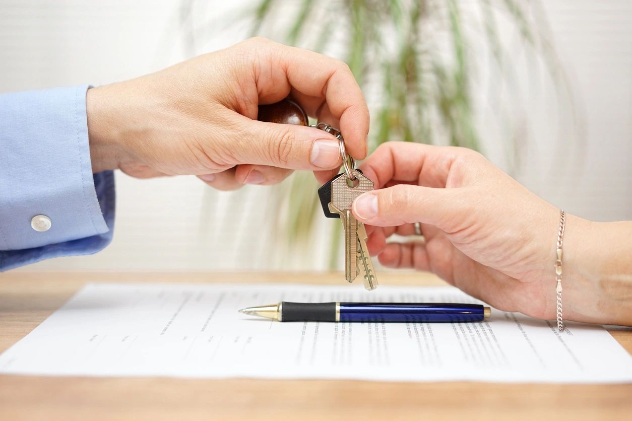 Handing over house keys during a real estate transaction.