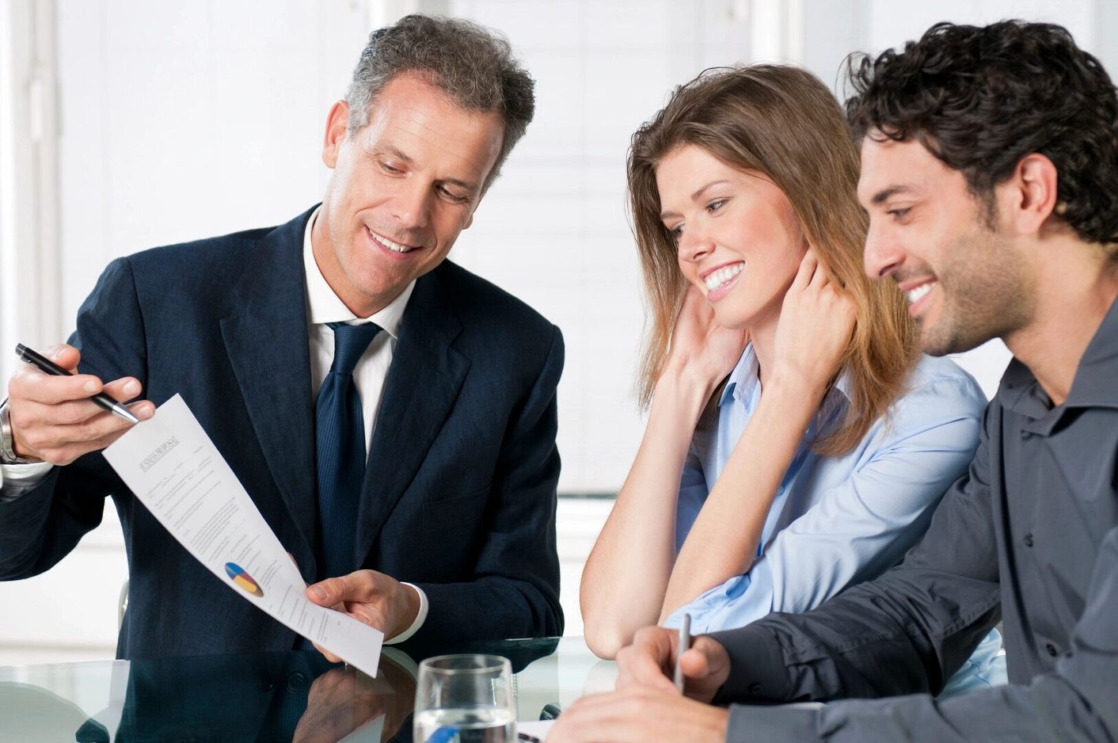 Businessman presenting a document to a couple in a meeting.