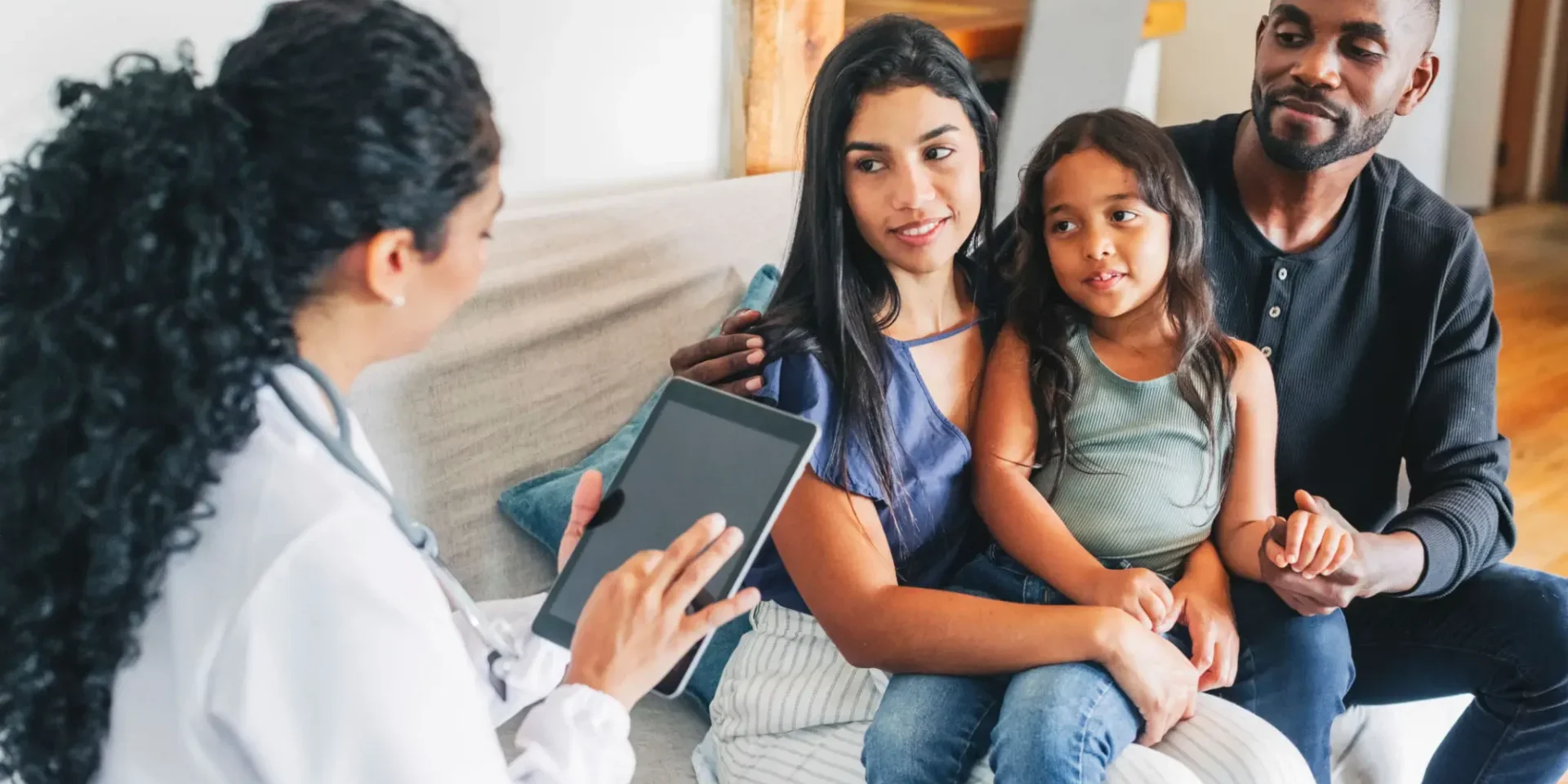 Doctor consulting a mother and her two children in a clinic.